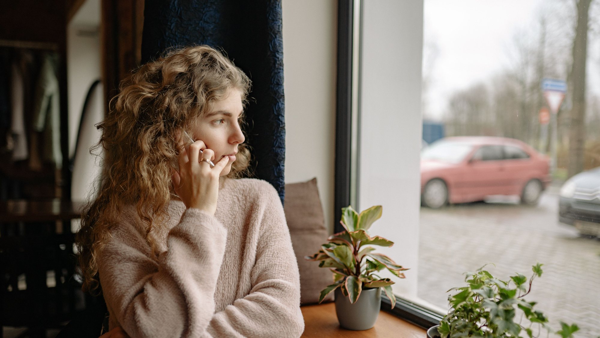 A customer on the phone, watching the street for a technician who has not arrived